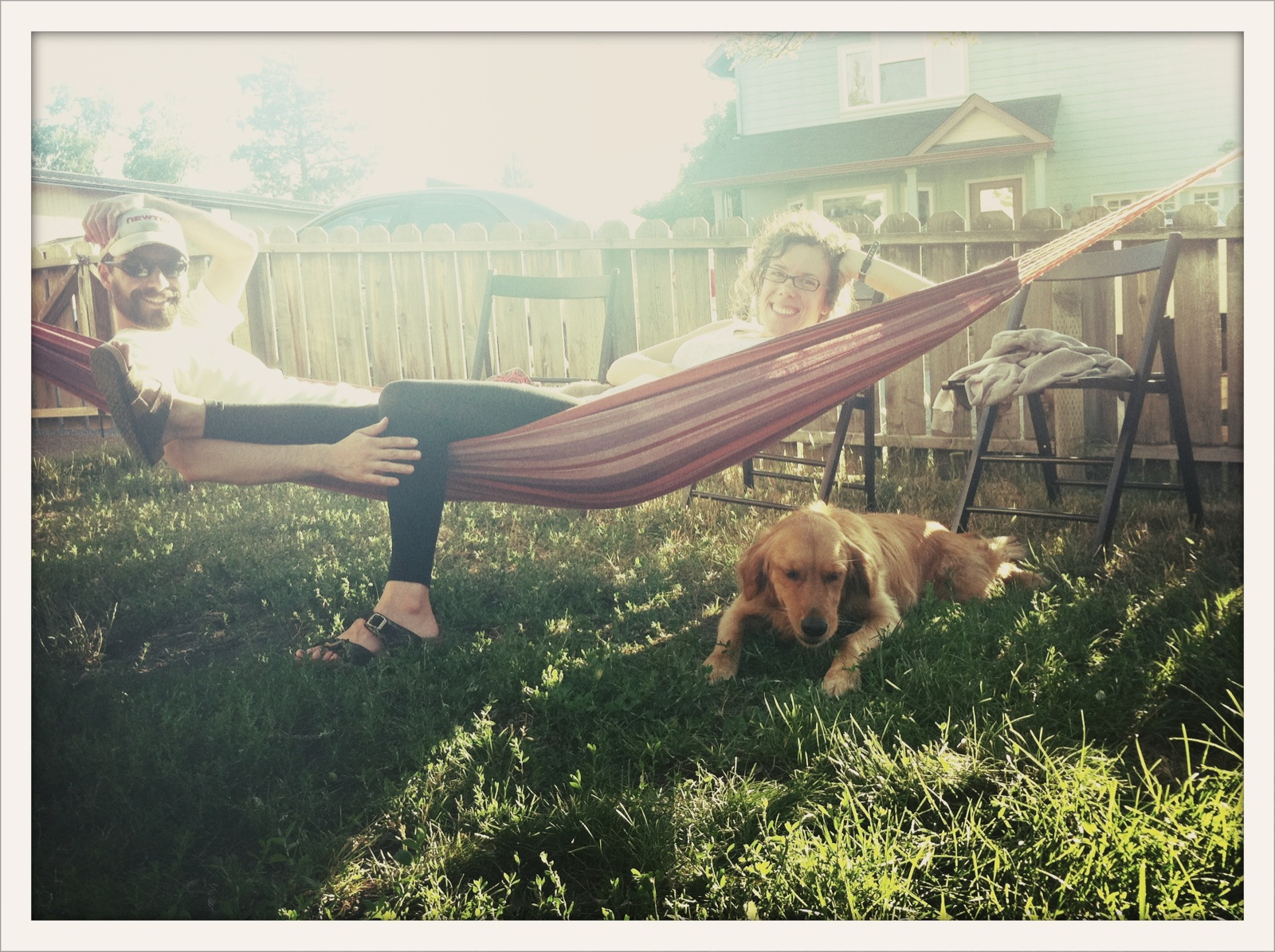 a-young-couple-relaxing-in-the-backyard-hammock-on-a-warm-sunny-afternoon-or-evening-with-the-dog-in_t20_OxGE6g